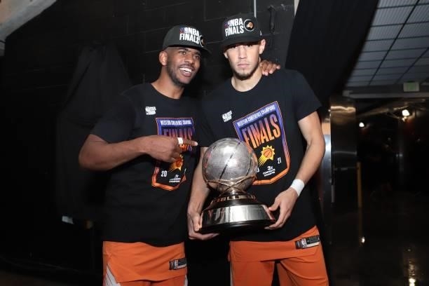 Chris Paul and Devin Booker of the Phoenix Suns pose for a photo holding the Western Conference Finals Trophy after winning the Western Conference...