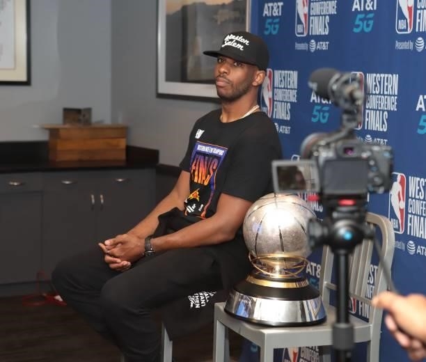 Chris Paul of the Phoenix Suns sits with the Western Conference Finals Trophy after winning the Western Conference Finals of the 2021 NBA Playoffs on...