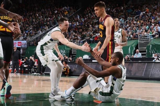 Pat Connaughton helps up Khris Middleton of the Milwaukee Bucks during Game 5 of the Eastern Conference Finals of the 2021 NBA Playoffs on July 1,...