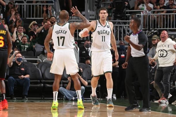 Brook Lopez hi-fives P.J. Tucker of the Milwaukee Bucks during Game 5 of the Eastern Conference Finals of the 2021 NBA Playoffs on July 1, 2021 at...