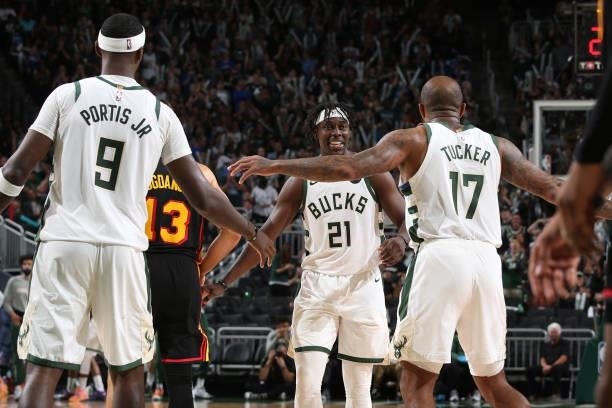 Jrue Holiday hi-fives P.J. Tucker and Bobby Portis of the Milwaukee Bucks during Game 5 of the Eastern Conference Finals of the 2021 NBA Playoffs on...