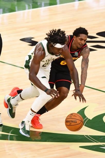 Jrue Holiday of the Milwaukee Bucks and Lou Williams of the Atlanta Hawks reach for the ball during Game 5 of the Eastern Conference Finals of the...