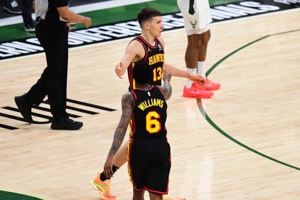 Bogdan Bogdanovic of the Atlanta Hawks high-fives teammate Lou Williams during the game against the Milwaukee Bucks during Game 5 of the Eastern...