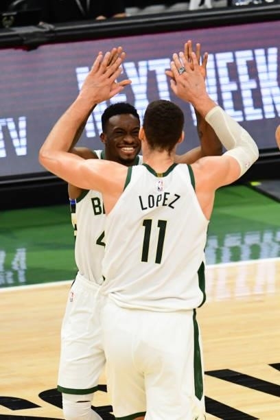 Thanasis Antetokounmpo of the Milwaukee Bucks high-fives teammate Brook Lopez during the game against the Atlanta Hawks during Game 5 of the Eastern...