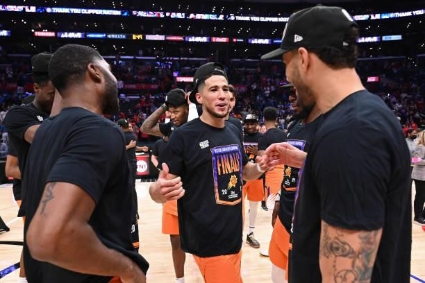 Devin Booker of the Phoenix Suns talks to E'Twaun Moore of the Phoenix Suns and Abdel Nader of the Phoenix Suns after the game against the LA...