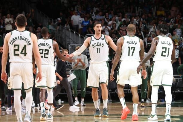 Brook Lopez hi-fives Khris Middleton, P.J. Tucker, Pat Connaughton and Jrue Holiday of the Milwaukee Bucks during Game 5 of the Eastern Conference...