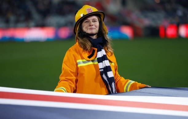 Emergency Services workers unfurl a flag during the 2021 AFL Round 16 match between the Geelong Cats and the Essendon Bombers at GMHBA Stadium on...