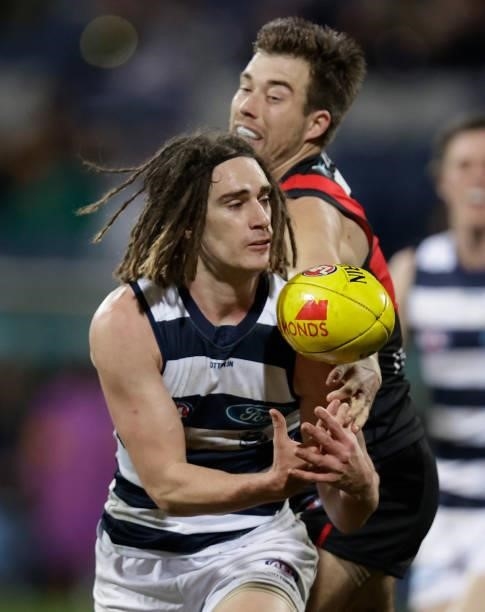 Gryan Miers of the Cats and Zach Merrett of the Bombers compete for the ball during the 2021 AFL Round 16 match between the Geelong Cats and the...