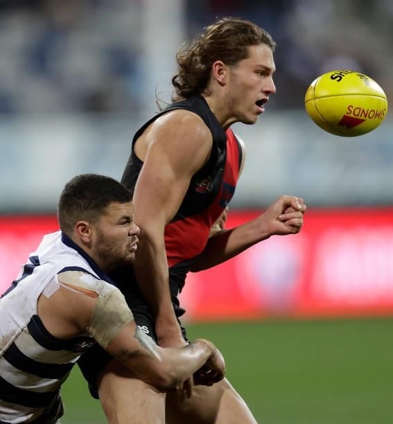Archie Perkins of the Bombers is tackled by Brandan Parfitt of the Cats during the 2021 AFL Round 16 match between the Geelong Cats and the Essendon...