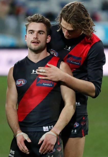 Will Snelling and Harrison Jones of the Bombers look dejected after a loss during the 2021 AFL Round 16 match between the Geelong Cats and the...