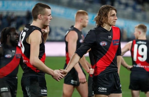 Nikolas Cox and Harrison Jones of the Bombers look dejected after a loss during the 2021 AFL Round 16 match between the Geelong Cats and the Essendon...