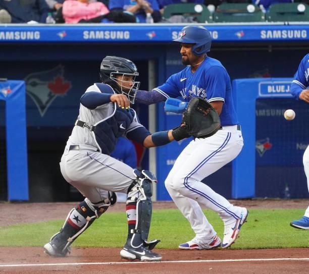 Marcus Semien of the Toronto Blue Jays beats the throw to Francisco Mejia of the Tampa Bay Rays to score on a one run single by Vladimir Guerrero Jr....