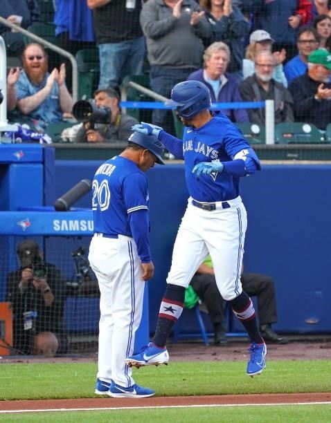 George Springer of the Toronto Blue Jays celebrates with Luis Rivera after hitting a home run during the first inning against the Tampa Bay Rays at...