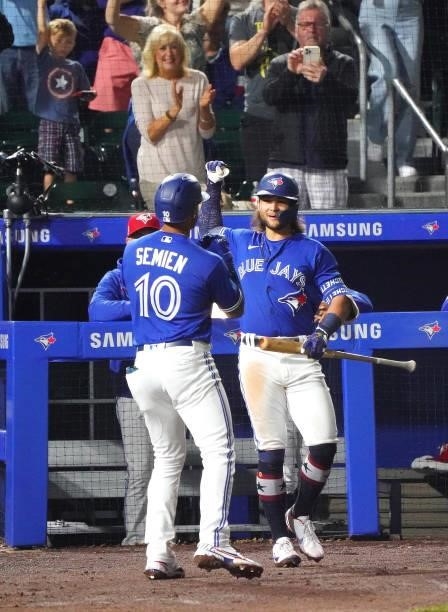 Marcus Semien of the Toronto Blue Jays celebrates with Bo Bichette after hitting a home run during the seventh inning against the Tampa Bay Rays at...