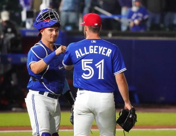 Nick Allgeyer of the Toronto Blue Jays and Reese McGuire congratulate each other after defeating the Tampa Bay Rays 11-1 at Sahlen Field on July 2,...