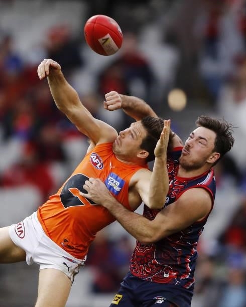 Toby Greene of the Giants and Michael Hibberd of the Demons compete for the ball during the 2021 AFL Round 16 match between the Melbourne Demons and...