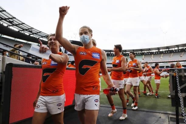 Lachie Whitfield and Harry Himmelberg of the Giants leave the field after a win during the 2021 AFL Round 16 match between the Melbourne Demons and...
