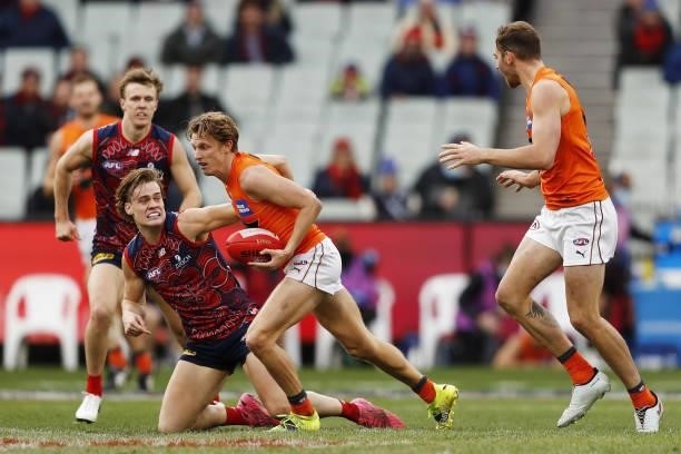 Lachie Whitfield of the Giants is tackled by Trent Rivers of the Demons during the 2021 AFL Round 16 match between the Melbourne Demons and the GWS...