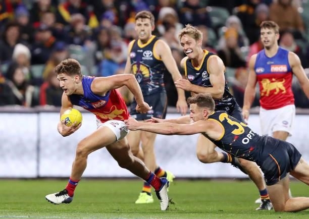 Zac Bailey of the Lions runs the ball against Brodie Smith of the Crows during the 2021 AFL Round 16 match between the Adelaide Crows and the...