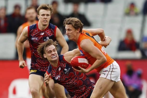 Lachie Whitfield of the Giants is tackled by Trent Rivers of the Demons during the 2021 AFL Round 16 match between the Melbourne Demons and the GWS...