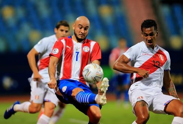 Carlos Gonzalez of Paraguay competes for the ball against Renato Tapia of Peru during the Quarterfinal match between Peru and Paraguay as part of...