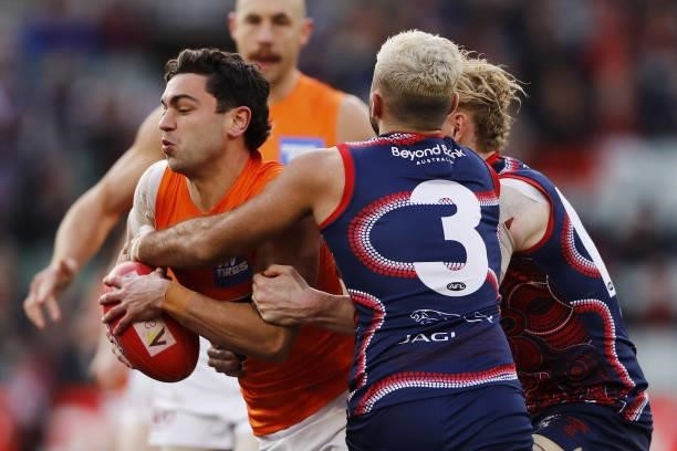 Tim Taranto of the Giants is tackled by Clayton Oliver and Christian Salem of the Demons during the 2021 AFL Round 16 match between the Melbourne...