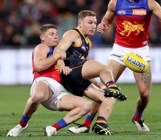 Rory Laird of the Crows kicks the ball against Dayne Zorko of the Lions during the 2021 AFL Round 16 match between the Adelaide Crows and the...