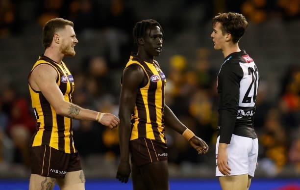 Connor Rozee of the Power, Blake Hardwick and Changkuoth Jiath of the Hawks exchange words during the 2021 AFL Round 16 match between the Hawthorn...