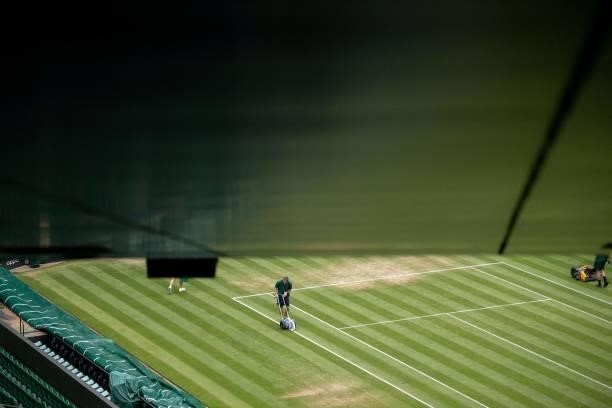 Ground Staff prepare the lines and the grass on Centre Court ahead of the day's play on the sixth day of the 2021 Wimbledon Championships at The All...
