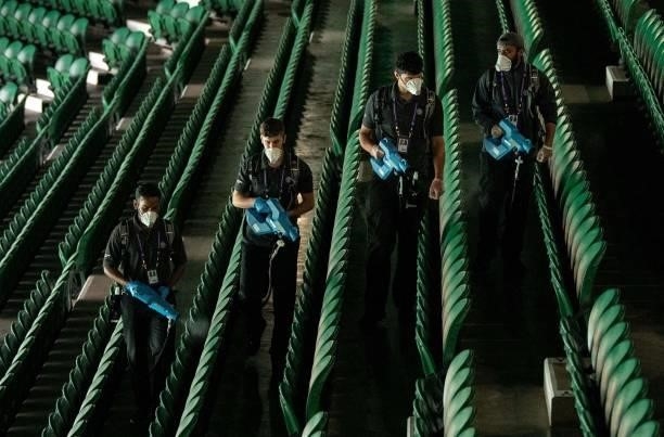 Housekeeping staff using mist sprayers to disinfect the seats in Centre Court ahead on the sixth day of the 2021 Wimbledon Championships at The All...