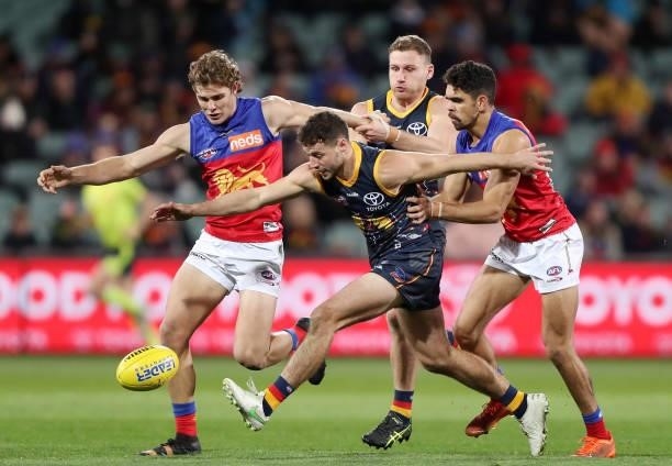 Luke Brown of the Crows, Deven Robertson of the Lions, Charlie Cameron of the Lions and Rory Laird of the Crows during the 2021 AFL Round 16 match...