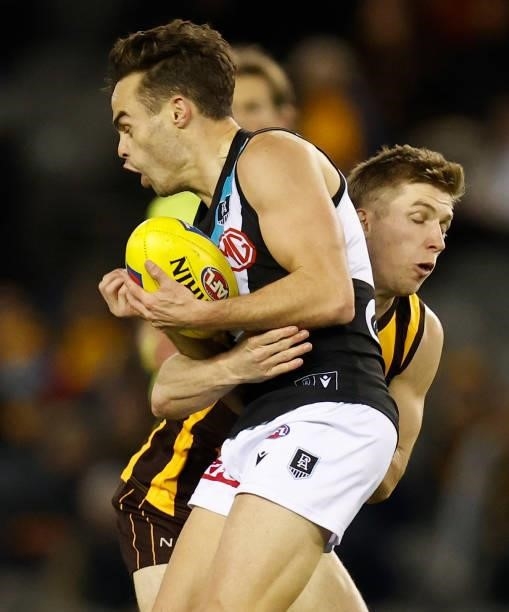 Karl Amon of the Power is tackled by Dylan Moore of the Hawks during the 2021 AFL Round 16 match between the Hawthorn Hawks and the Port Adelaide...