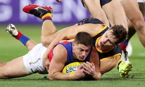 Dayne Zorko of the Lions is tackled by Jake Kelly of the Crows during the 2021 AFL Round 16 match between the Adelaide Crows and the Brisbane Lions...