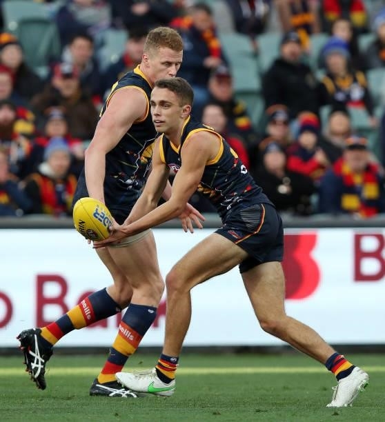 Lachlan Sholl of the Crows handpasses the ball during the 2021 AFL Round 16 match between the Adelaide Crows and the Brisbane Lions at Adelaide Oval...
