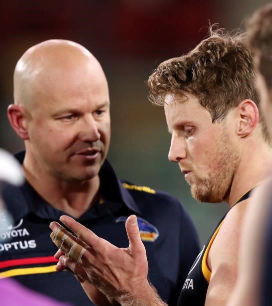 Rory Sloane of the Crows looks at his strapped finger while Matthew Nicks, Senior Coach of the Crows talks to him at 3 quarter time during the 2021...