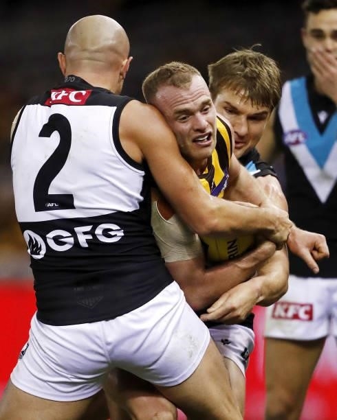 Tom Mitchell of the Hawks is tackled by Sam Powell-Pepper of the Power and Ollie Wines of the Power during the 2021 AFL Round 16 match between the...