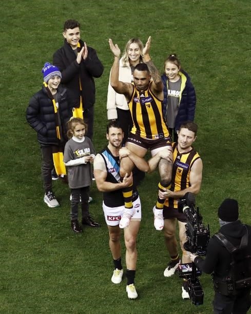 Shaun Burgoyne of the Hawks is chaired off the ground for his 400th game by Travis Boak of the Power and Liam Shiels of the Hawks with his family...