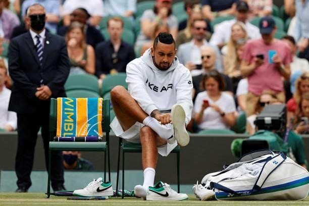 Australia's Nick Kyrgios puts on a pair of trainers ahead of his men's singles third round match against Canada's Felix Auger-Aliassime on the sixth...