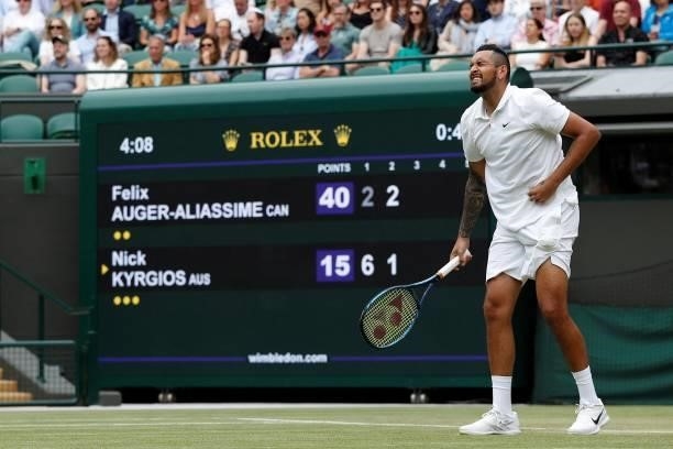 Australia's Nick Kyrgios holds his stomach in pain after serving against Canada's Felix Auger-Aliassime during their men's singles third round match...