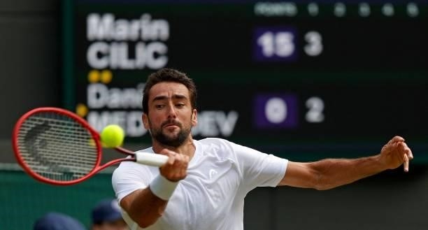 Croatia's Marin Cilic returns against Russia's Daniil Medvedev during their men's singles third round match on the sixth day of the 2021 Wimbledon...