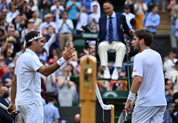 Switzerland's Roger Federer greets Britain's Cameron Norrie after winning their men's singles third round match on the sixth day of the 2021...