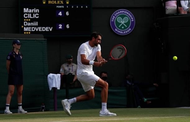Croatia's Marin Cilic returns against Russia's Daniil Medvedev during their men's singles third round match on the sixth day of the 2021 Wimbledon...