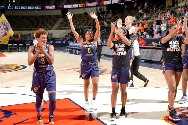 Danielle Robinson, Kelsey Mitchell and Lindsay Allen of the Indiana Fever cheer to the crowd after the game against the Connecticut Sun on July 3,...