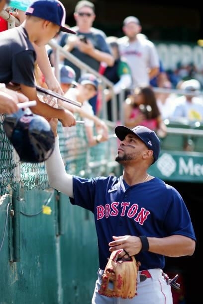Xander Bogaerts of the Boston Red Sox signs autographs before the game between the Boston Red Sox and the Oakland Athletics at Oakland Coliseum on...