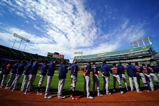 Members of the Boston Red Sox stand on the field during the National Anthem before the game between the Boston Red Sox and the Oakland Athletics at...