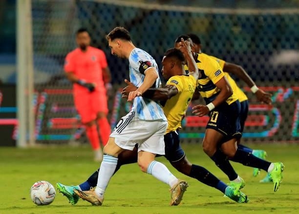 Lionel Messi of Argentina competes for the ball with Pervis Estupinan and Jhegson Mendez of Ecuador ,during the Quarterfinal match between Argentina...