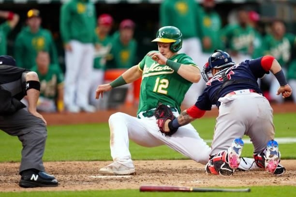 Christian Vázquez of the Boston Red Sox tags out Sean Murphy of the Oakland Athletics at home plate during the game at Oakland Coliseum on Saturday,...