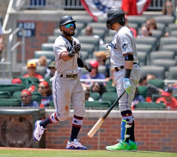 Starling Marte and Miguel Rojas of the Miami Marlins celebrate a run in the fourth inning against the Atlanta Braves at Truist Park on July 4, 2021...