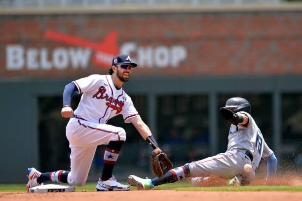 Dansby Swanson of the Atlanta Braves fields a late throw as Miguel Rojas of the Miami Marlins steals second base in the fourth inning at Truist Park...