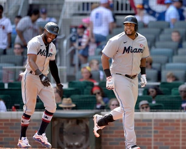 Starling Marte and Jesús Aguilar of the Miami Marlins walk to the dugout after Aguilar's two run home run in the ninth inning against the Atlanta...